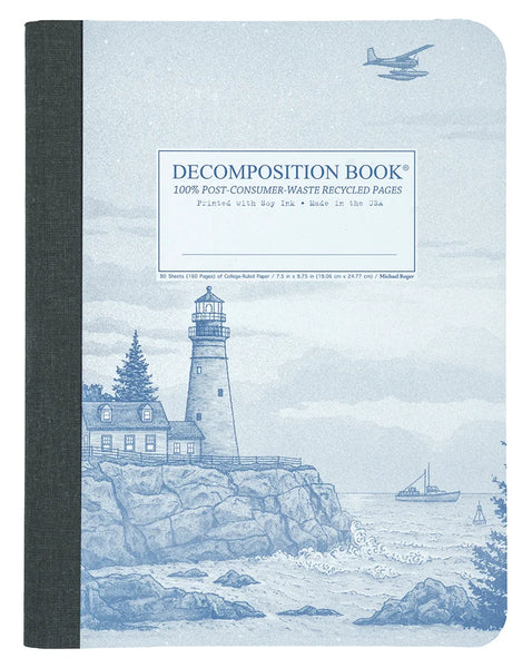 A decomposition book with a dark gray fabric spine and a light blue cover featuring a lighthouse illustration and the text 'DECOMPOSITION BOOK' and '100% POST-CONSUMER-WASTE RECYCLED PAGES'.
