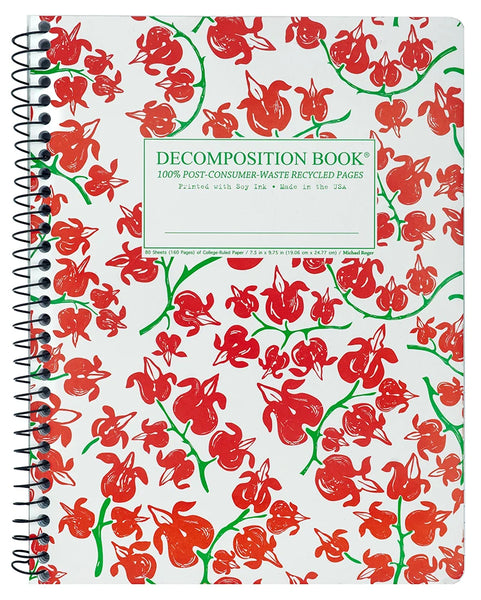 A spiral-bound decomposition notebook with a white page background covered in a red and green floral pattern (bleeding hearts). The center label reads 'DECOMPOSITION BOOK' and '100% POST-CONSUMER-WASTE RECYCLED PAGES'.