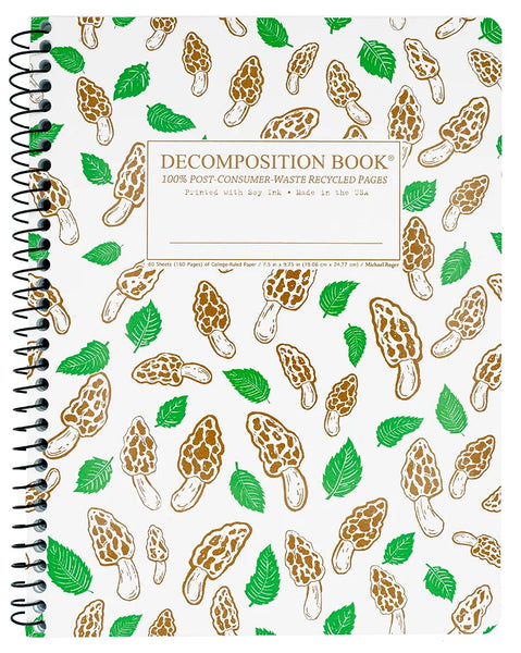 A spiral-bound decomposition book with a white cover covered in a repeating pattern of brown mushroom illustrations and green leaves. The center features a beige label with the text 'DECOMPOSITION BOOK 100% POST CONSUMER WASTE RECYCLED PAGES'. Printed with Soy Ink. Made in the USA