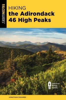 Book cover of 'Hiking the Adirondack 46 High Peaks' with a scenic view of mountains and trees