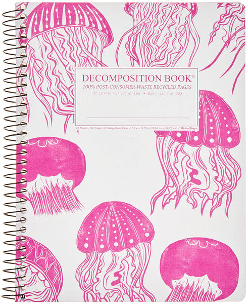 A spiral-bound decomposition book with a white cover printed in bright pink with jellyfish illustrations. A white rectangular label on the front reads 'DECOMPOSITION BOOK' with smaller text below. 100% Post-Consumer-Waster Recycled Pages. Printed with Soy Ink. Made in the USA