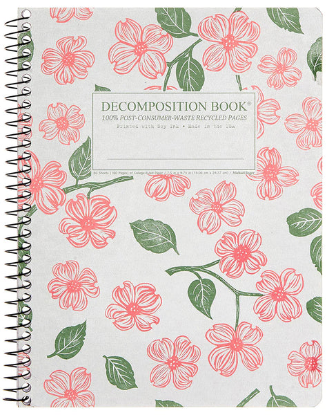 A spiral-bound decomposition book with a white cover with pink dogwood on the cover. The front cover reads 'DECOMPOSITION BOOK' and '100% POST-CONSUMER WASTE RECYCLED PAGES. Printed with Soy Ink. Made in the USA.